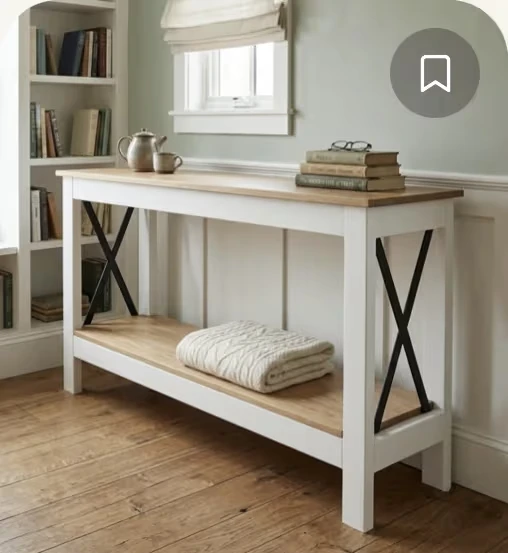 A white farmhouse console with a natural wood top, styled in a light-filled living room.